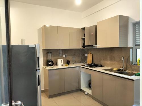 a kitchen with white cabinets and a stainless steel refrigerator at Santorini Resort Apartment 3 Bed rooms- Negombo Beach & Airport in Negombo