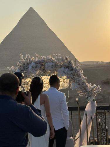a bride and groom standing in front of the pyramids at Comfort Inn Pyramids Hotel in Cairo