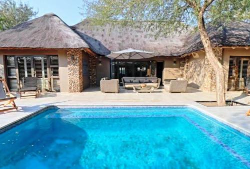 eine Villa mit Swimmingpool und ein Resort in der Unterkunft Luvivane Luxury Villa in Marloth Park