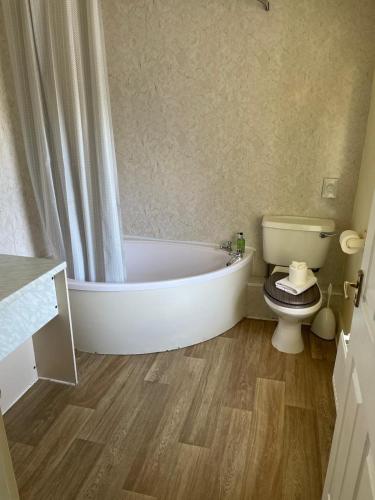 a bathroom with a bath tub and a toilet at The Bridge Inn in Reeth