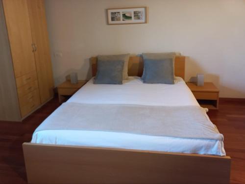 a bedroom with a large bed with blue pillows at Solaria House appartamenti con cucina a 200 MT dalla Basilica di Padre Pio e 600 MT dall'ospedale Casa Sollievo della Sofferenza in San Giovanni Rotondo