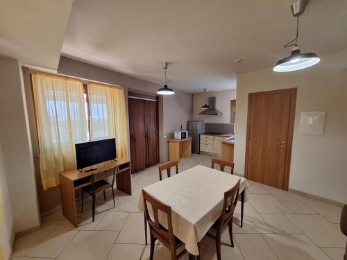 a living room with a table and a kitchen at Solaria House appartamenti con cucina a 200 MT dalla Basilica di Padre Pio e 600 MT dall'ospedale Casa Sollievo della Sofferenza in San Giovanni Rotondo