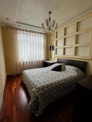 un dormitorio con una cama y una ventana en Квартира на Шевченка, en Kamianets-Podilskyi