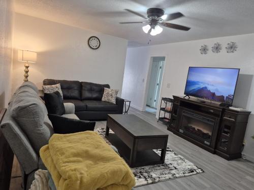 a living room with a couch and a flat screen tv at Emmanuel Fulton Park Condominium in Tulsa