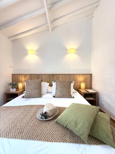 a bedroom with a white bed with a hat on it at Hotel Casa Terra in Villa de Leyva