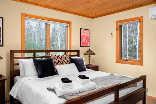 a bedroom with a bed with towels on it at You Betcha - Charming 3BR Arcade & Near Lutsen & Grand Marais in Grand Marais