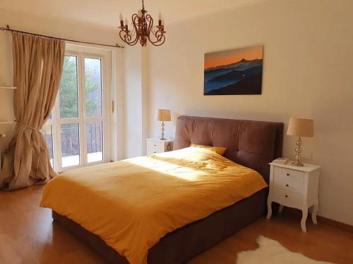 a bedroom with a bed and a large window at Luxury 3 bedroom Grand Chalet in Perosa Argentina