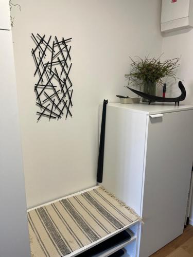 a white refrigerator in a kitchen with a plant on the wall at Jungle apartment in Brno