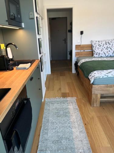 a room with a bed and a kitchen with a counter at Jungle apartment in Brno