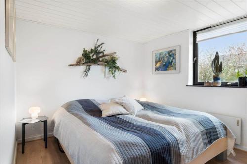 a white bedroom with a bed and a window at LF11102-Struer-Snerlevej-2 in Struer