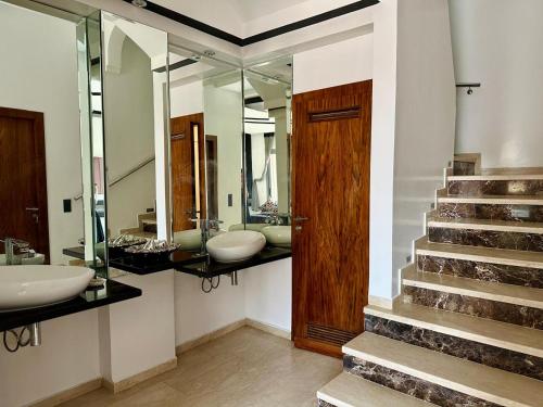 a bathroom with two sinks and a staircase with mirrors at 5-star luxury villa with private pool in Marrakech