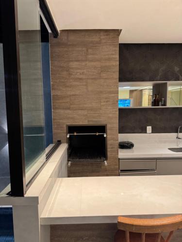 eine Küche mit einem Kamin in der Mitte in der Unterkunft Sanzecasadapraia in São José da Coroa Grande