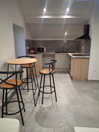 a kitchen with two tables and two stools at Appartement loft in Mandeure