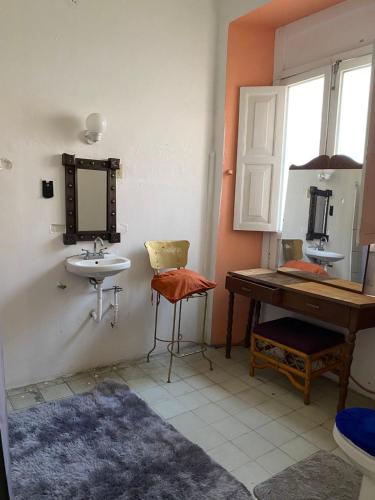 a bathroom with a sink and a mirror and a desk at Maska Mansion Expiatorio Gdl Guest house in Guadalajara