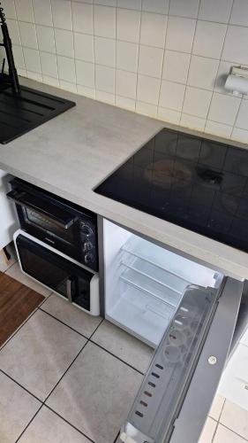a kitchen with an open oven with its door open at Bright T2 Workspace & WiFi Fiber, 5 min to Sophia Antipolis, 10 to Antibes in Mougins