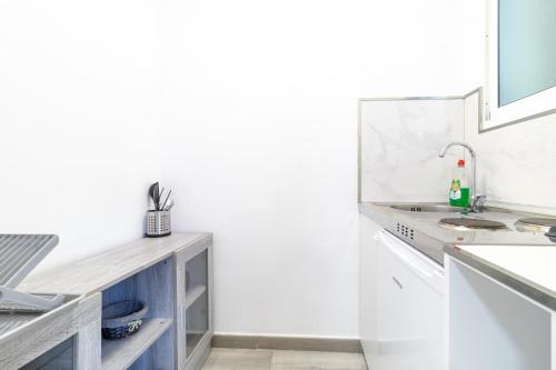 a white kitchen with a sink and a counter at Villa Amir in Fuengirola