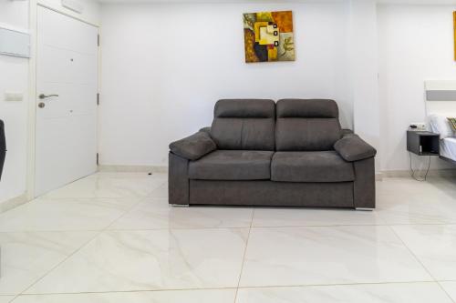 a couch sitting in a living room with a tile floor at Villa Amir in Fuengirola