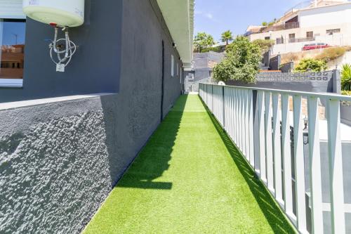 a walkway with grass on the side of a building at Villa Amir in Fuengirola