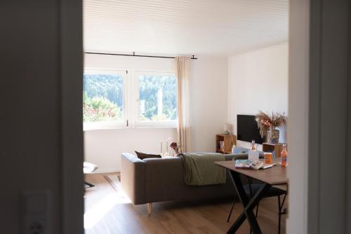 a living room with a couch and a table and a window at Kindvriendelijk vakantiehuis in Winterberg met tuin - Modern & rustig gelegen in Winterberg