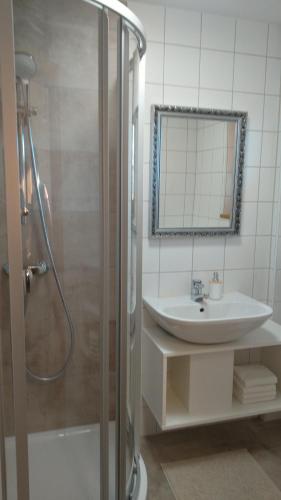 a bathroom with a shower and a sink and a mirror at Appartement Antretter in Westendorf
