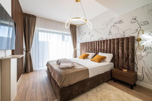 Maison Lumière - A modern Designer Apartment in Central Bucharest في بوخارست: غرفة نوم بها سرير ونافذة كبيرة