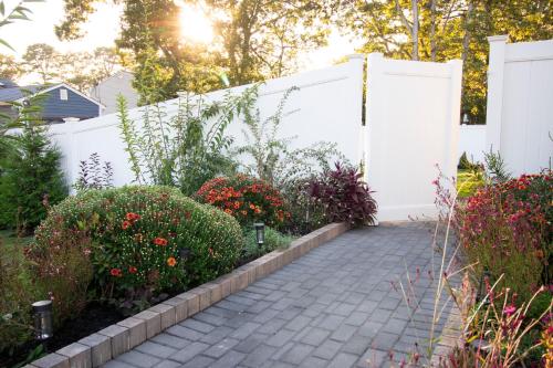 a garden with a white fence and some flowers at Exceptional & Central, Garden Suite, Top Amenities & Care! in Central Islip