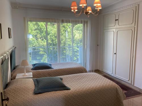 a bedroom with two beds and a large window at Sea Side apartment in Cannes