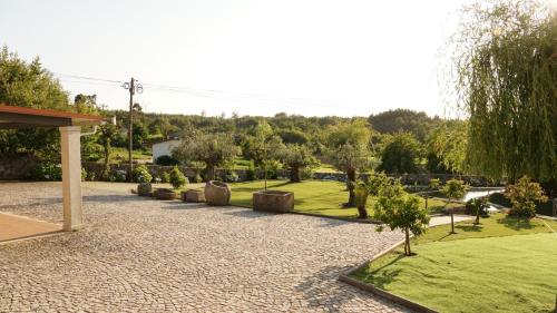 a garden with trees and grass and a pavilion at Casa da Biquinha in Vouzela