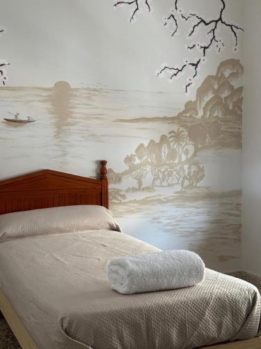 a bedroom with a bed with a painting on the wall at Casa rural habitaciones Dar Alpujarra in Órgiva