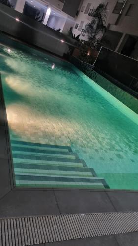 a swimming pool with blue water in a building at DAR Sheerazade in Hammamet Nord