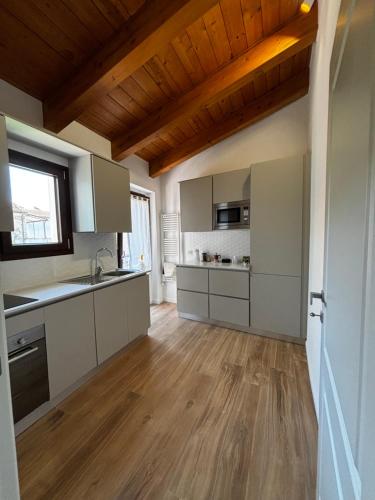 a kitchen with white cabinets and a wooden ceiling at La Locanda del Barone in Torraca