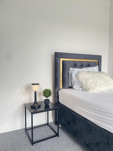 a bed with a side table with a lamp on it at Grille Apartment Minden in Minden