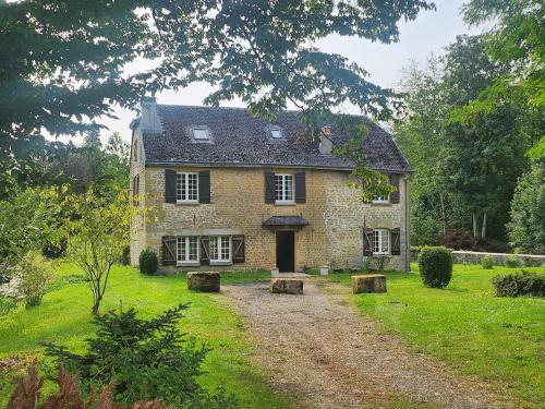 una vieja casa de piedra con un camino de tierra delante de ella en Gite rural La petite Belgique - Lamécourt - 12 personnes - 6 chambres, en Bazeilles