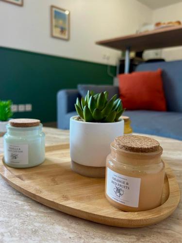 two jars on a wooden cutting board with a plant at Un cocon tout confort à La Rochelle - proche gare & plages in La Rochelle
