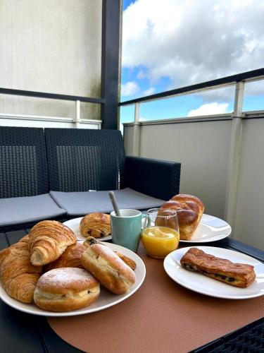 a table with two plates of pastries and orange juice at Un cocon tout confort à La Rochelle - proche gare & plages in La Rochelle