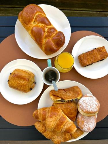 a table topped with plates of pastries and bread at Un cocon tout confort à La Rochelle - proche gare & plages in La Rochelle