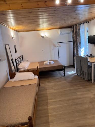 a room with two beds and a table in it at Tsakoniki filoxenia! in Leonidion