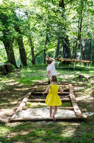 a little girl in a yellow dress walking across a bridge at Château d’Orion in Orion