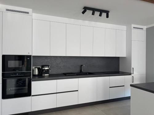 a white kitchen with a sink and a stove at Apartment Victoria in Kraymorie