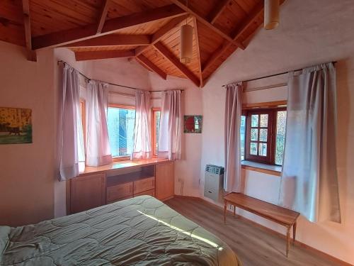 a bedroom with a bed and some windows at Casa Sueño in San Martín de los Andes