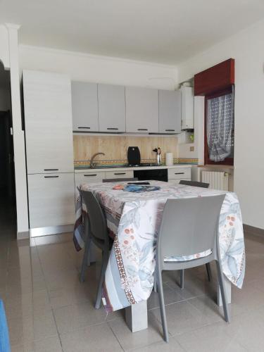a kitchen with a table with chairs and white cabinets at Stella marina in Mattinata