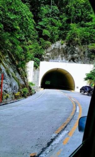 a tunnel on a road with a car driving through it at Auntie's in Tanza