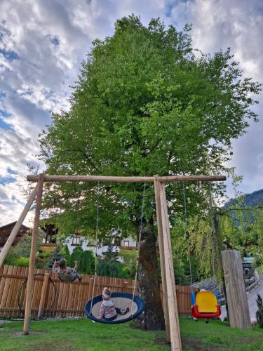 a baby sitting on a swing in a yard at Das Steinmetzhäuschen in Virgen