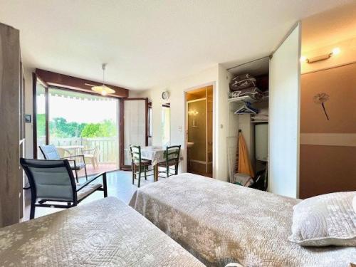 CazaubonにあるApartment in Barbotan-les-Thermesのベッド2台とテーブルと椅子のある寝室