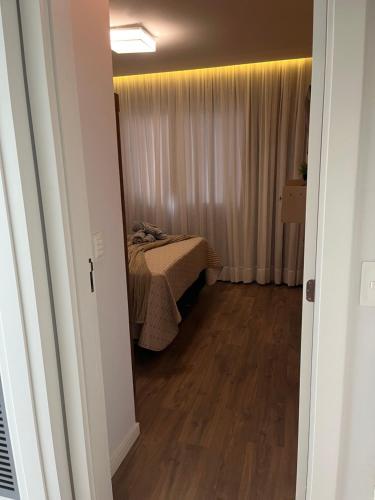 a bedroom with a bed in a room with wooden floors at Studio aconchegante e tranquilo! Perto de tudo! in Indaial