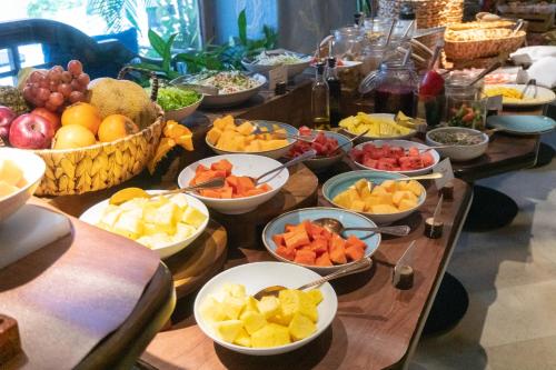a table with many bowls of fruits and vegetables at Nacar Hotel Cartagena, Curio Collection by Hilton in Cartagena de Indias