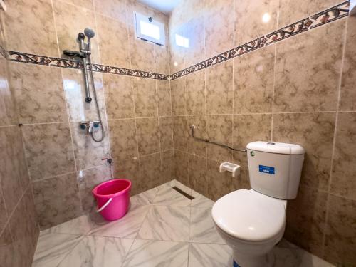 a bathroom with a toilet and a shower and a bucket at Tamraght Waves Retreat in Tamraght Ouzdar