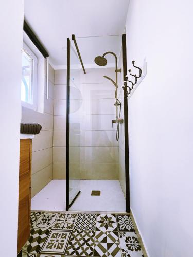 a bathroom with a shower with a tiled floor at Polka - RDC - Centre ville - Terrasse in Auch