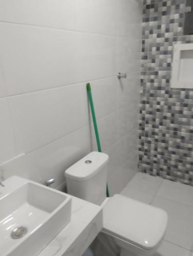 a white bathroom with a toilet and a sink at A Matriarca in Bom Jesus da Lapa