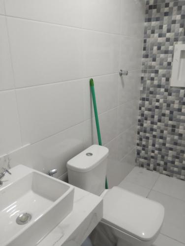 a white bathroom with a toilet and a sink at A Matriarca in Bom Jesus da Lapa